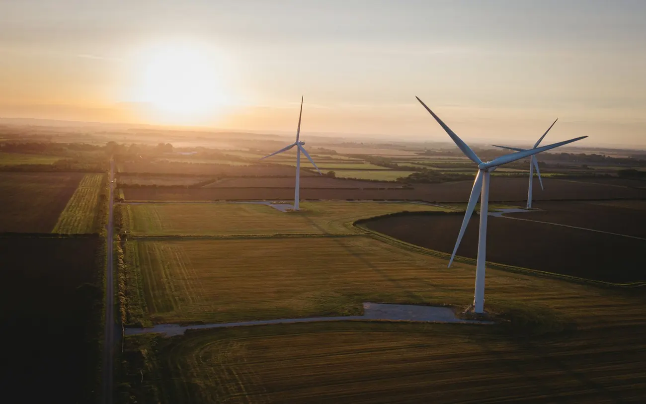Windkraftanlagen über weiter Feldlandschaft im goldenen Abendlicht