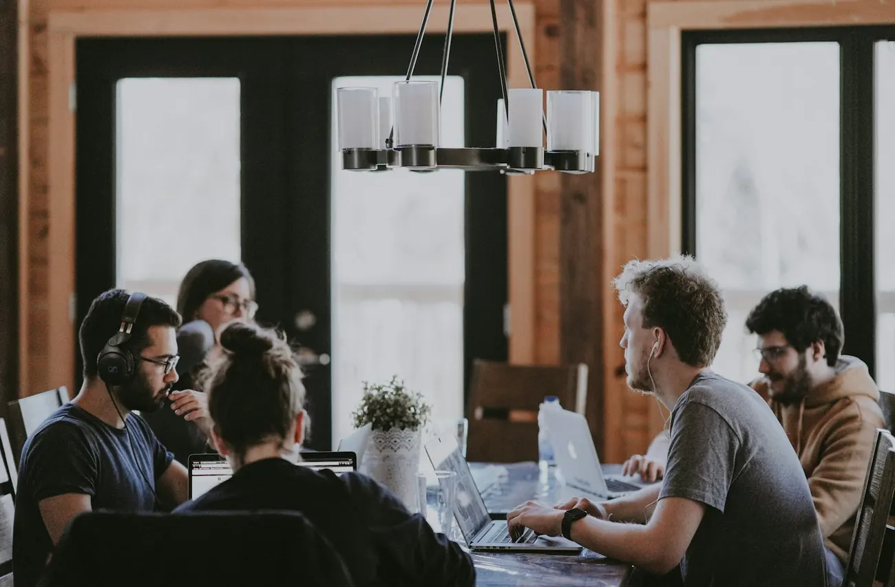 Kleines Team arbeitet an Laptops in einem hellen Coworking-Raum